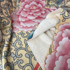 Close-up of floral fabric with pink flowers and intricate patterns.