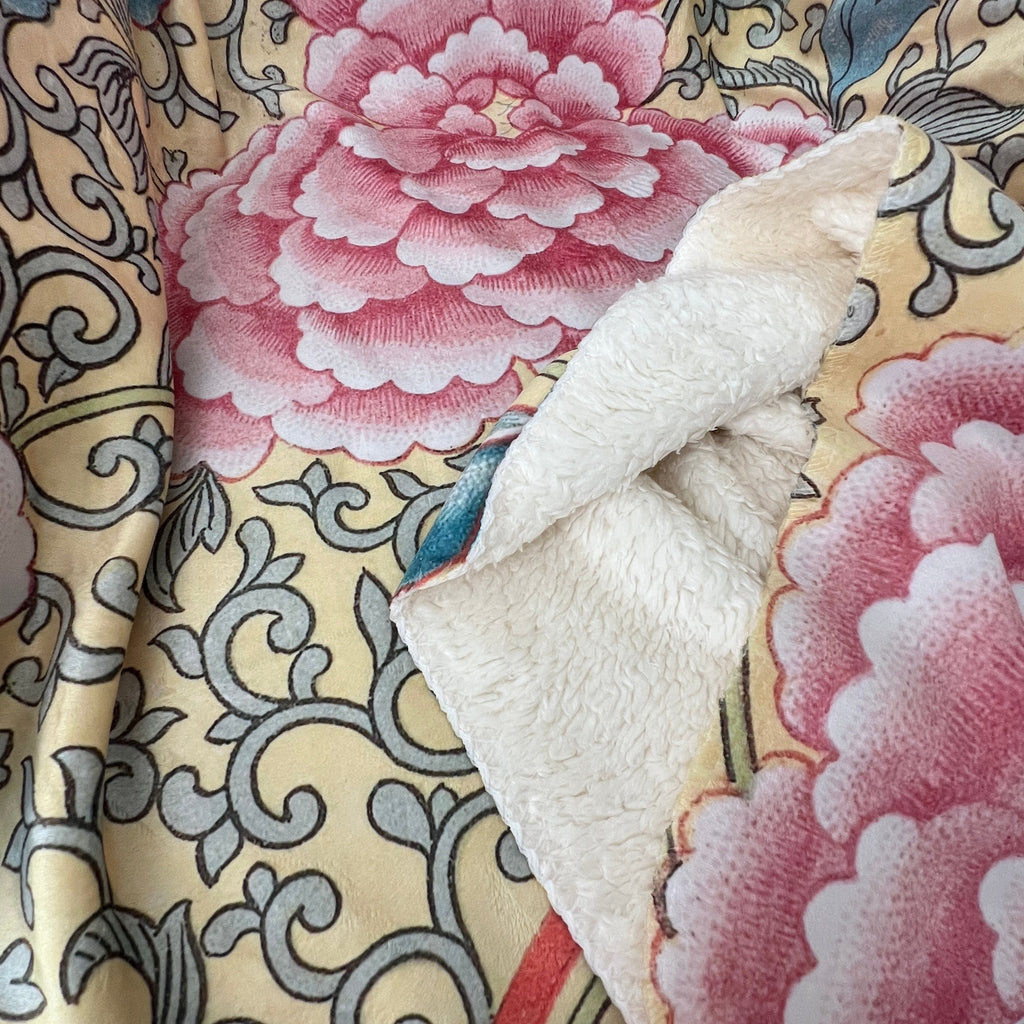 Close-up of floral fabric with pink flowers and intricate patterns.